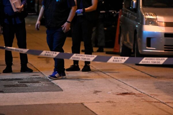 Krew widoczna za kordonem policyjnym, w miejscu, którym Jimmy Sham, przywódca Obywatelskiego Frontu Praw Człowieka, CHRF, został zaatakowany młotkami przez cztery do pięciu osób, dzielnica Mongkok w Koulun, Hongkong, 16.10.2019 r. (Philip Fong/AFP via Getty Images)