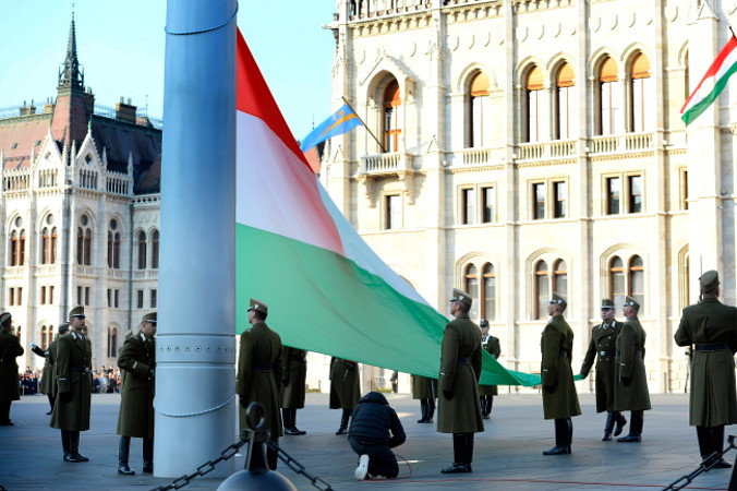 Gwardia honorowa wciąga flagę państwową na maszt podczas oficjalnych obchodów święta narodowego Węgier, w 63. rocznicę wybuchu rewolucji węgierskiej i walk o niepodległość w 1956 r. – przeciwko rządom komunistycznym i ZSRS, Budapeszt, przed budynkiem parlamentu, 23.10.2019 r. (TAMAS KOVACS/PAP/EPA)