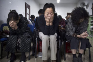 Chińscy chrześcijanie modlą się podczas nabożeństwa w podziemnym niezależnym kościele protestanckim, Pekin, 12.10.2014 r. Chiny, kraj oficjalnie ateistyczny, nakładają wiele ograniczeń na chrześcijan i zezwalają na praktykowanie wiary tylko w zatwierdzonych przez państwo kościołach (Kevin Frayer/Getty Images)