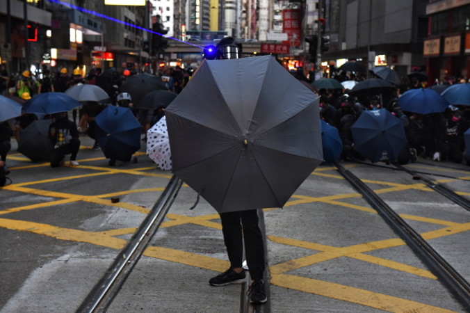 Protestujący osłaniają się parasolami podczas wiecu na rzecz demokracji w Hongkongu, 2.11.2019 r. (MIGUEL CANDELA/PAP/EPA)