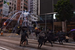 Gaz łzawiący z eksplodujących pojemników unosi się nad protestującymi, Hongkong, 2.11.2019 r. (MIGUEL CANDELA/PAP/EPA)