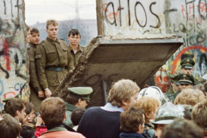Mieszkańcy Berlina Zachodniego gromadzą się przed murem berlińskim rano 11.11.1989 r., obserwują wschodnioniemieckich strażników granicznych wyburzających fragment muru<br/>(Gerard Malie / AFP via Getty Images)