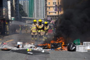 Strażacy gaszą barykadę, która została podpalona przez protestujących, Sai Wan Ho, Hongkong, 11.11.2019 r. (JEROME FAVRE/PAP/EPA)