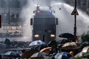 Policja strzela z armatki wodnej zamontowanej na pojeździe, a protestujący rzucają koktajl Mołotowa, Uniwersytet Politechniczny w Hongkongu, 17.11.2019 r. (Anthony Kwan / Getty Images)