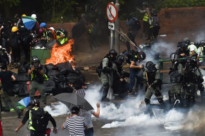 Policja (po prawej) dokonuje aresztowań, gdy protestujący (po lewej) próbują znaleźć bezpieczne wyjście z kampusu Uniwersytetu Politechnicznego w Hongkongu, dzielnica Hung Hom, Hongkong, 18.11.2019 r.<br/>(Ye Aung Thu / AFP via Getty Images)
