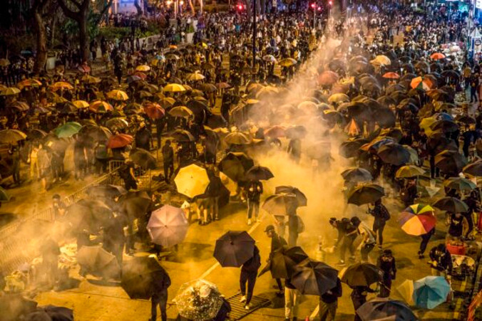 Protestujący podczas próby marszu w kierunku Uniwersytetu Politechnicznego w Hongkongu w dzielnicy Hung Hom, gdy policja strzela gazem łzawiącym, Hongkong, 18.11.2019 r. (Dale de la Rey/AFP via Getty Images)