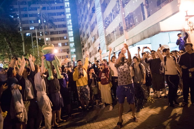 Zwolennicy demokracji świętują porażkę propekińskiego radnego Juniusa Ho, Tuen Mun, Hongkong, 25.11.2019 r. (CHAN CHEUNK/PAP/EPA)