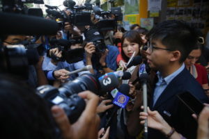 Prodemokratyczny działacz i przywódca Joshua Wong rozmawia z mediami, gdy przybył, by oddać głos w wyborach do rad dzielnicowych, Hongkong, Chiny, 24.11.2019 r. (FAZRY ISMAIL/PAP/EPA)