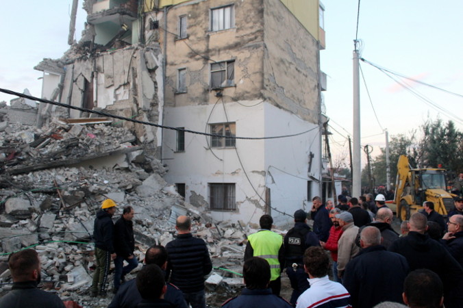Ludzie szukają tych, którzy przeżyli w gruzach budynku po silnym trzęsieniu ziemi, jakie nawiedziło Thumanë, Albania, 26.11.2019 r. (MALTON DIBRA/PAP/EPA)