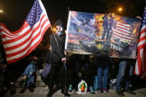 Protestujący na rzecz demokracji trzymają flagi Stanów Zjednoczonych i sztandar z prezydentem USA Donaldem Trumpem podczas wiecu w Święto Dziękczynienia w Edinburgh Place, Hongkong, 28.11.2019 r. (JEROME FAVRE/PAP/EPA)
