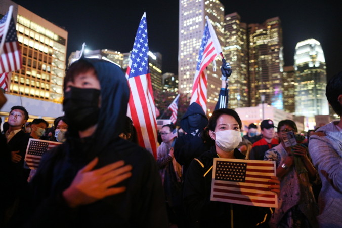 Protestujący na rzecz demokracji trzymają flagi narodowe Stanów Zjednoczonych podczas wiecu w Święto Dziękczynienia na Edinburgh Place, Hongkong, 28.11.2019 r. Protestujący podziękowali prezydentowi USA Donaldowi Trumpowi za podpisanie Ustawy o prawach człowieka i demokracji w Hongkongu<br/>(JEROME FAVRE/PAP/EPA)