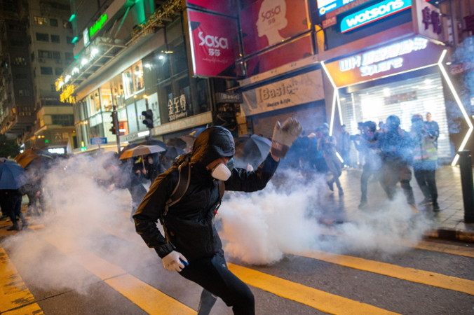 Protestujący na rzecz demokracji po tym, jak policja wystrzeliła gaz łzawiący podczas wiecu w Tsim Sha Tsui, Hongkong, 24.12.2019 r. (JEROME FAVRE/PAP/EPA)