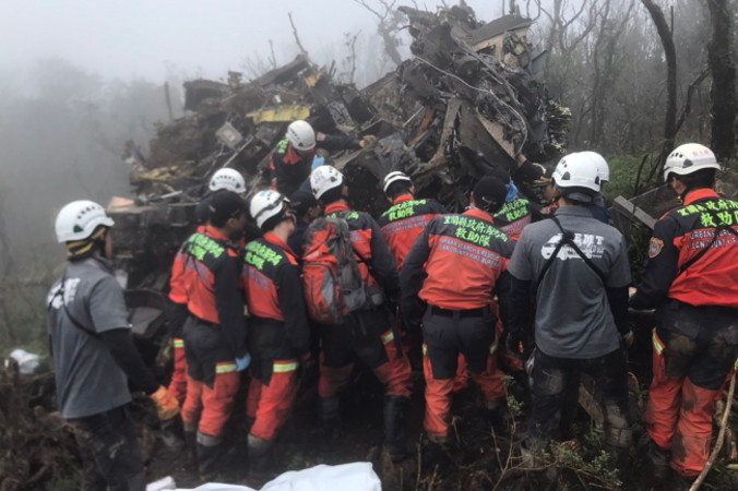 Na zdjęciu udostępnionym przez Biuro Straży Pożarnej powiatu Yilan, ang. Yilan County Fire Bureau, widać ratowników dokonujących inspekcji miejsca katastrofy wojskowego śmigłowca UH-60M w pobliżu gór w powiecie Yilan na Tajwanie, 2.01.2020 r. (YILAN COUNTY FIRE BUREAU HANDOUT/PAP/EPA)
