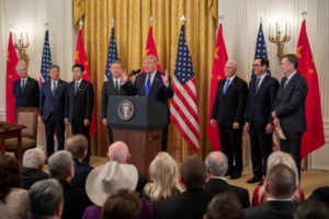 Prezydent USA Donald J. Trump (pośrodku, po prawej), wicepremier Chin Liu He (pośrodku, po lewej) oraz wiceprezydent USA Mike Pence (trzeci od prawej), minister skarbu Steven Mnuchin (drugi od prawej), amerykański przedstawiciel ds. handlu Robert Lighthizer (pierwszy od prawej), a także inni urzędnicy USA i Chin uczestniczą w ceremonii podpisania porozumienia handlowego w East Room w Białym Domu, Waszyngton, 15.01.2020 r. (ERIK S. LESSER/PAP/EPA)