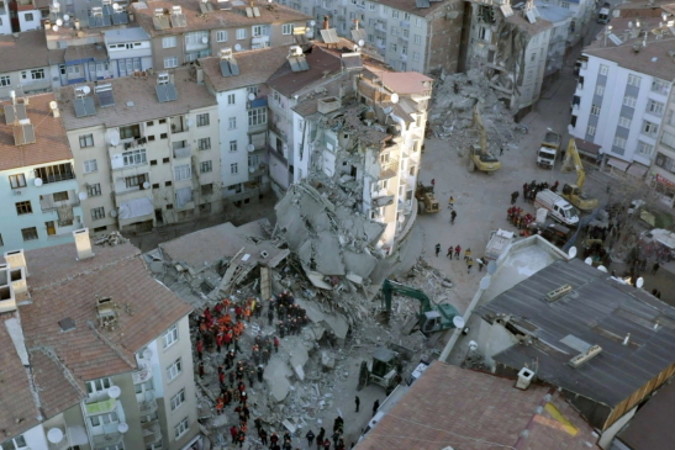 Na zdjęciu udostępnionym przez Humanitarian Relief Foundation, IHH, zrobionym przez drona, widać ratowników poszukujący ocalałych w gruzach budynku po trzęsieniu ziemi w Elazig, Turcja, 25.01.2020 r. (HUMANITARIAN RELIEF FOUNDATION HANDOUT/PAP/EPA)