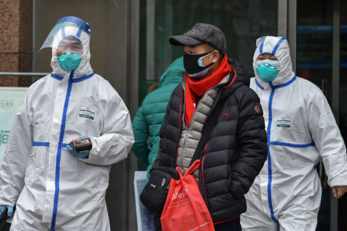 Personel medyczny w kombinezonach ochronnych przed szpitalem w Wuhan, 26.01.2020 r.<br/>(Hector Retamal/AFP via Getty Images)