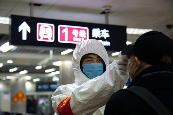 Pracownik służby zdrowia sprawdza temperaturę ciała mężczyzny wchodzącego do metra w Pekinie, 26.01.2020 r. (Betsy Joles/Getty Images)