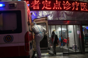 Członek personelu medycznego, ubrany w odzież ochronną, aby powstrzymać rozprzestrzenianie się wirusa, który po raz pierwszy został wykryty w Wuhan i spowodował już ofiary śmiertelne, wsiada do karetki w szpitalu Czerwonego Krzyża w Wuhan, ang. Wuhan Red Cross Hospital, Wuhan 25.01.2020 r. (Hector Retamal / AFP przez Getty Images)
