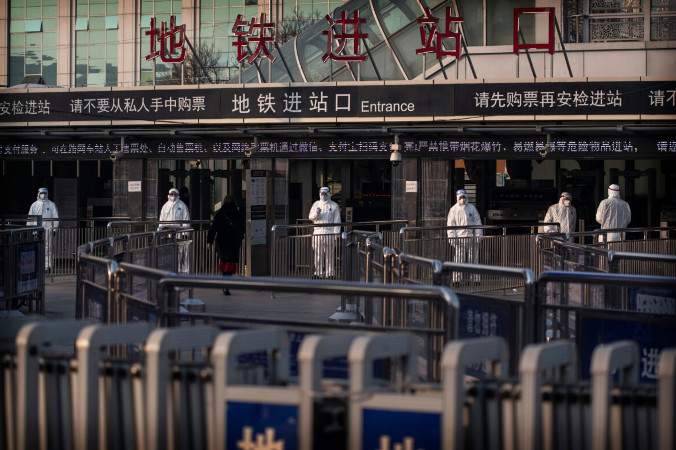 Pracownicy chińskiej służby zdrowia czekają, aby sprawdzić temperaturę podróżnych wchodzących na stację metra podczas Chińskiego Nowego Roku i Festiwalu Wiosny, Pekin, 25.01.2020 r. (Kevin Frayer/Getty Images)