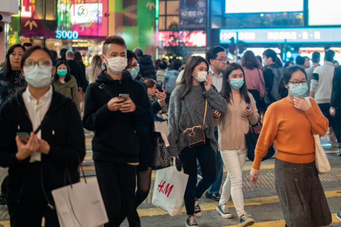 Przechodnie noszą maski na twarzy, gdy przechodzą przez przejście dla pieszych w dzielnicy Causeway Bay w Hongkongu, 23.01.2020 r. (Anthony Kwan/Getty Images)