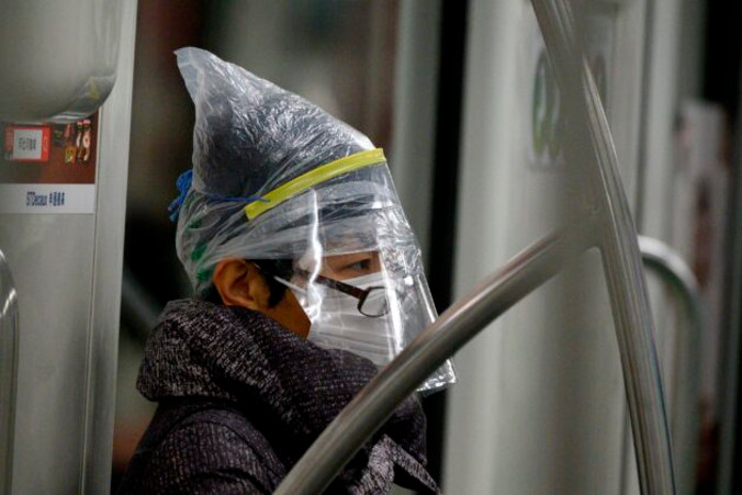 Pasażer metra w Szanghaju chroniący się przed zarażeniem koronawirusem, 12.02.2020 r.<br/>(NOEL CELIS/AFP via Getty Images)