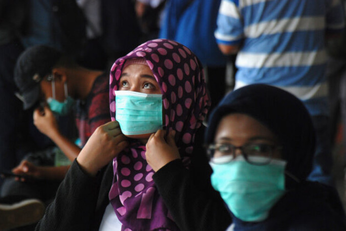 Kobiety w maskach na twarzy czekają na stacji kolejowej w Bandung, w prowincji Jawa Zachodnia, Indonezja, 5.03.2020 r. (Timur Matahari/AFP via Getty Images)