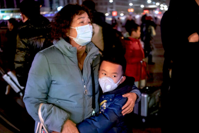 Chłopiec obejmuje krewną wsiadającą do pociągu na dworcu kolejowym w Pekinie, 21.01.2020 r.<br/>(Kevin Frayer / Getty Images)