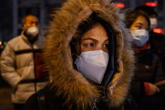 Pracownicy biurowi w Pekinie w maskach ochronnych w kolejce do autobusu po pracy, 2.03.2020 r.<br/>(Kevin Frayer / Getty Images)