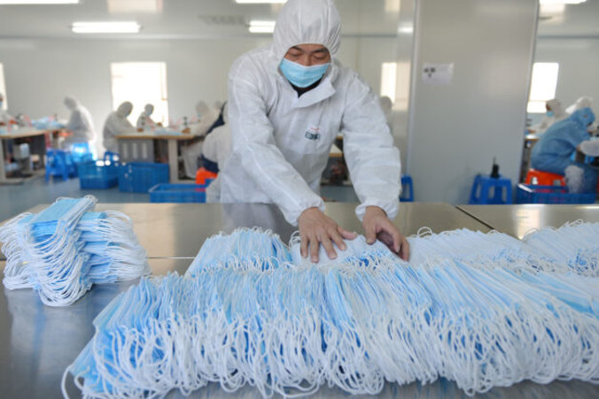 Pracownik fabryki w Nanjing, Nankin, w chińskiej prowincji Jiangsu sortuje maseczki ochronne, 18.02.2020 r. (STR/AFP via Getty Images)