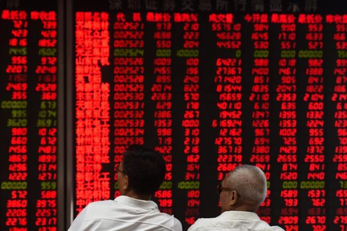 Inwestorzy sprawdzają ruch cen na giełdzie, Pekin, 15.06.2016 r. (Greg Baker/AFP/Getty Images)