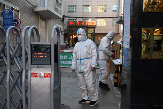 Ochroniarze w kombinezonach ochronnych przy wejściu do restauracji w Pekinie, 4.03.2020 r.<br/>(Greg Baker/AFP via Getty Images)