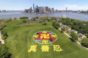 Tysiące praktykujących Falun Gong zebrało się na nowojorskiej wyspie Governors Island, aby wziąć udział w wydarzeniu formowania znaków, 18.05.2019 r. Emblemat składa się ze starożytnych symboli, żółta Śriwatsa symbolizuje buddyzm, a czerwono-czarne i czerwono-niebieskie symbole Taiji reprezentują taoizm (NTD)
