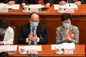 Szefowa administracji Hongkongu Carrie Lam (po prawej) i szef administracji Makau Ho Iat Seng (pośrodku) biorą udział w sesji otwierającej Ogólnochińskie Zgromadzenie Przedstawicieli Ludowych (OZPL) w Wielkiej Hali Ludowej w Pekinie, 22.05.2020 r. (LEO RAMIREZ/AFP via Getty Images)