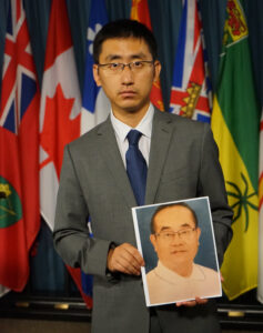 Praktykujący Falun Gong Paul Li trzyma zdjęcie swojego ojca Xiaobo Li na konferencji prasowej w Ottawie, 26.08.2016 r. (Pam McLennan / The Epoch Times)