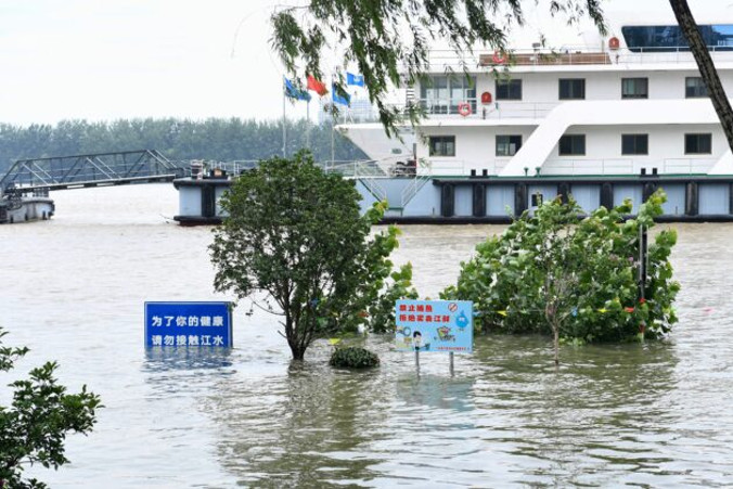 Tablice widoczne ponad wodami powodziowymi na brzegu rzeki Jangcy, Nankin w Chinach, 12.07.2020 r.<br/>(STR/AFP via Getty Images)
