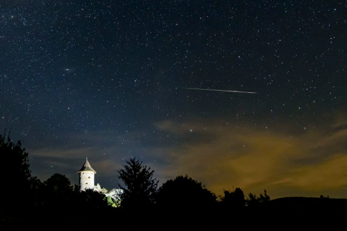 Meteor z roju Perseidów widoczny nad zamkiem Šomoška na Słowacji, obserwowany z Salgótarján na Węgrzech, w nocy 11.08.2020 r. (Peter Komka/PAP/EPA)