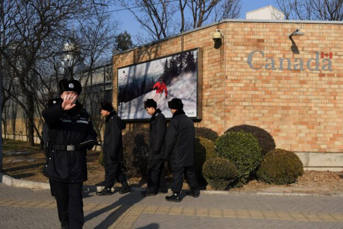 Chiński policjant próbuje przeszkodzić fotografowi przy Ambasadzie Kanady w Pekinie, 14.12.2018 r.<br/>(Greg Baker/AFP via Getty Images)
