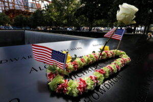 Kwiaty i flagi USA przy nazwisku Michaela Collinsa, nowojorskiego strażaka, w miejscu, gdzie stała południowa wieża World Trade Center, Nowy Jork, 19. rocznica ataku terrorystycznego z 11.09.2001 r., 11.09.2020 r. (PETER FOLEY/PAP/EPA)