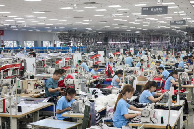 Pracownicy produkują kurtki puchowe w fabryce należącej do chińskiej firmy odzieżowej Bosideng, Nantong w prowincji Jiangsu na wschodzie Chin, 24.09.2019 r. (STR/AFP via Getty Images)