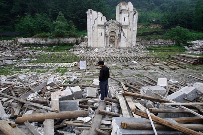 Mężczyzna próbuje uratować, co tylko się da, z gruzów zniszczonego kościoła w Bailu Township w Pengzhou, prowincja Syczuan, Chiny, 31.05.2008 r. (China Photos / Getty Images)