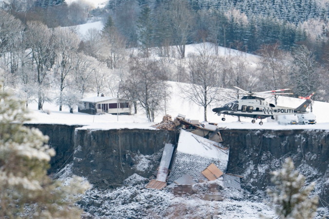 Ratownicy używają helikopterów do skanowania obszaru wielkiego osuwiska w miejscowości Ask w gminie Gjerdrum, Norwegia, 31.12.2020 r. (Fredrik Hagen/PAP/EPA)