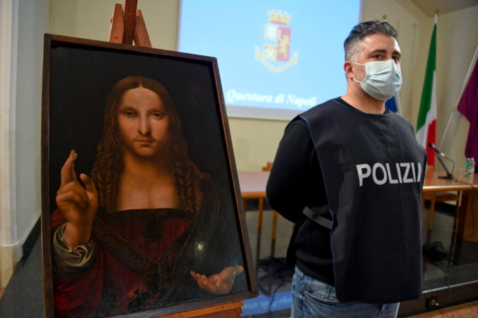 Policjant stoi obok odzyskanego obrazu „Salvator Mundi” w Neapolu, Włochy, 18.01.2021 r., wydane 19.01.2021 r. (CIRO FUSCO/PAP/EPA)