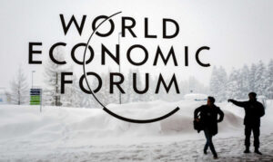 Pracownik ochrony koło pokrytego śniegiem Centrum Kongresowego w Davos wskazuje osobie drogę przed otwarciem dorocznej konferencji Światowego Forum Ekonomicznego (WEF) 2018 w Davos w Szwajcarii, 22.01.2018 r. (Fabrice Coffrini/AFP via Getty Images)