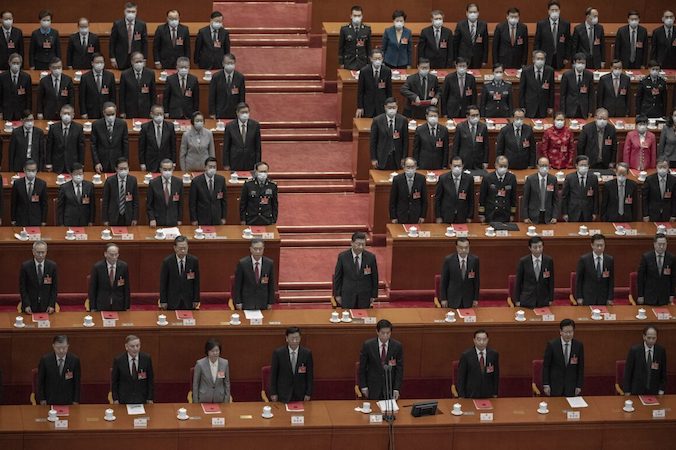 Chiński przywódca Xi Jinping (w środku) wraz z delegatami na Ogólnochińskie Zgromadzenie Przedstawicieli Ludowych stoi do hymnu podczas sesji kończącej konferencję marionetkowej legislatury partii w Wielkiej Hali Ludowej w Pekinie, Chiny, 11.03.2021 r. (Kevin Frayer / Getty Images)