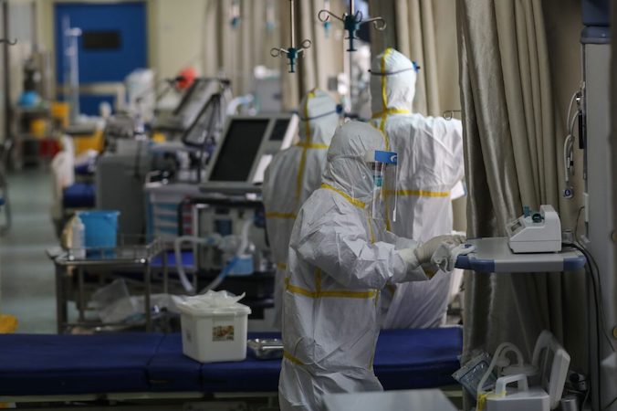 Pracownicy służby zdrowia dezynfekują sprzęt na oddziale, który służył jako oddział izolacyjny dla pacjentów zarażonych koronawirusem wywołującym COVID-19, szpital w Wuhan, Chiny, 12.03.2020 r. (STR/AFP via Getty Images)