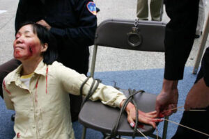 Rekonstrukcja jednej z metod tortur stosowanych przez chińskich urzędników w celu zmuszenia praktykujących Falun Gong do wyrzeczenia się wiary (dzięki uprzejmości Minghui.org)