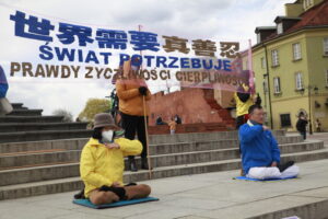 Praktykujący Falun Dafa wykonują ćwiczenie medytacyjne na pl. Zamkowym pod kolumną Zygmunta w Warszawie, 25.04.2021 r. (Karolina Olejniczak / The Epoch Times)