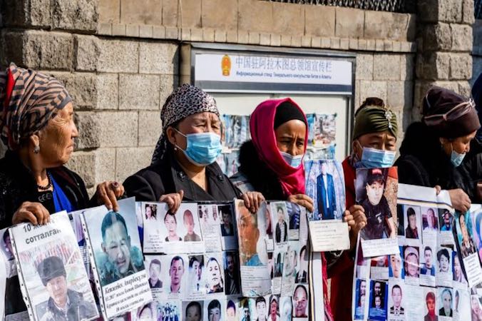 Grupa kobiet protestujących przed chińskim konsulatem w Ałma Acie, Kazachstan, domaga się bezpiecznego powrotu do domu dla swoich krewnych, którzy zaginęli, zostali aresztowani lub uwięzieni w chińskim regionie Xinjiang, 9.03.2021 r. (Abduaziz Madyrovi/AFP via Getty Images)