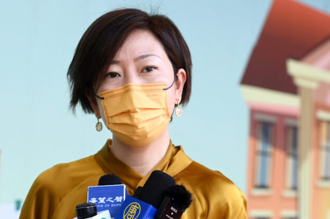 Sarah Liang, reporterka hongkońskiego wydania „The Epoch Times”, przemawia do lokalnych mediów przed szpitalem Queen Elizabeth w Hongkongu, 11.05.2021 r. (Song Pi-lung / The Epoch Times)