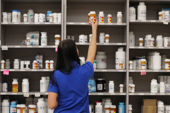 Technik farmaceutyczny sięga po buteleczkę leków z półki w centralnej aptece należącej do Intermountain Healthcare w Midvale w stanie Utah, 10.09.2018 r. (George Frey / Getty Images)